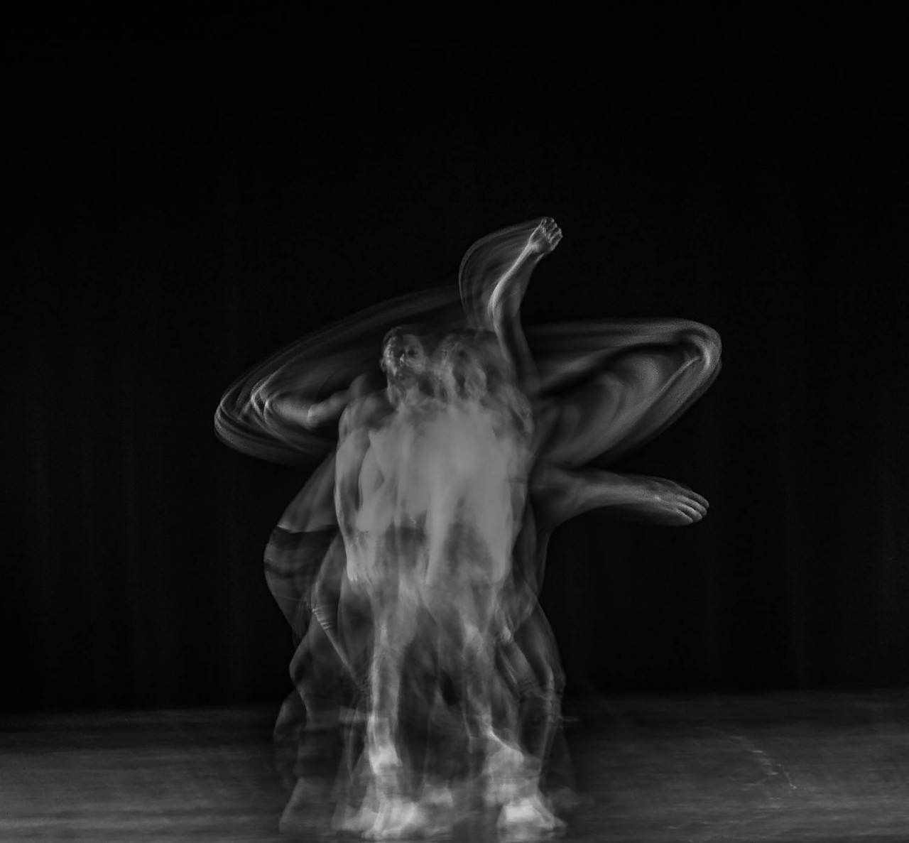 A black and white abstract photo depicting motion blur of a dancer on stage.