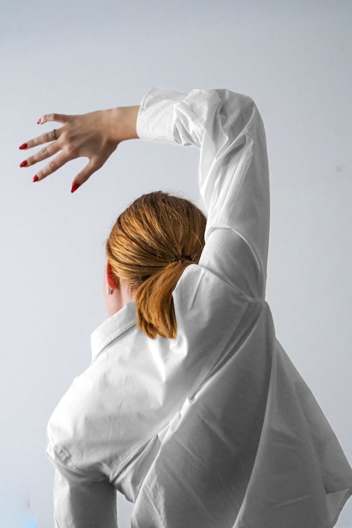 Artistic dance pose in white attire, showcasing grace and elegance.