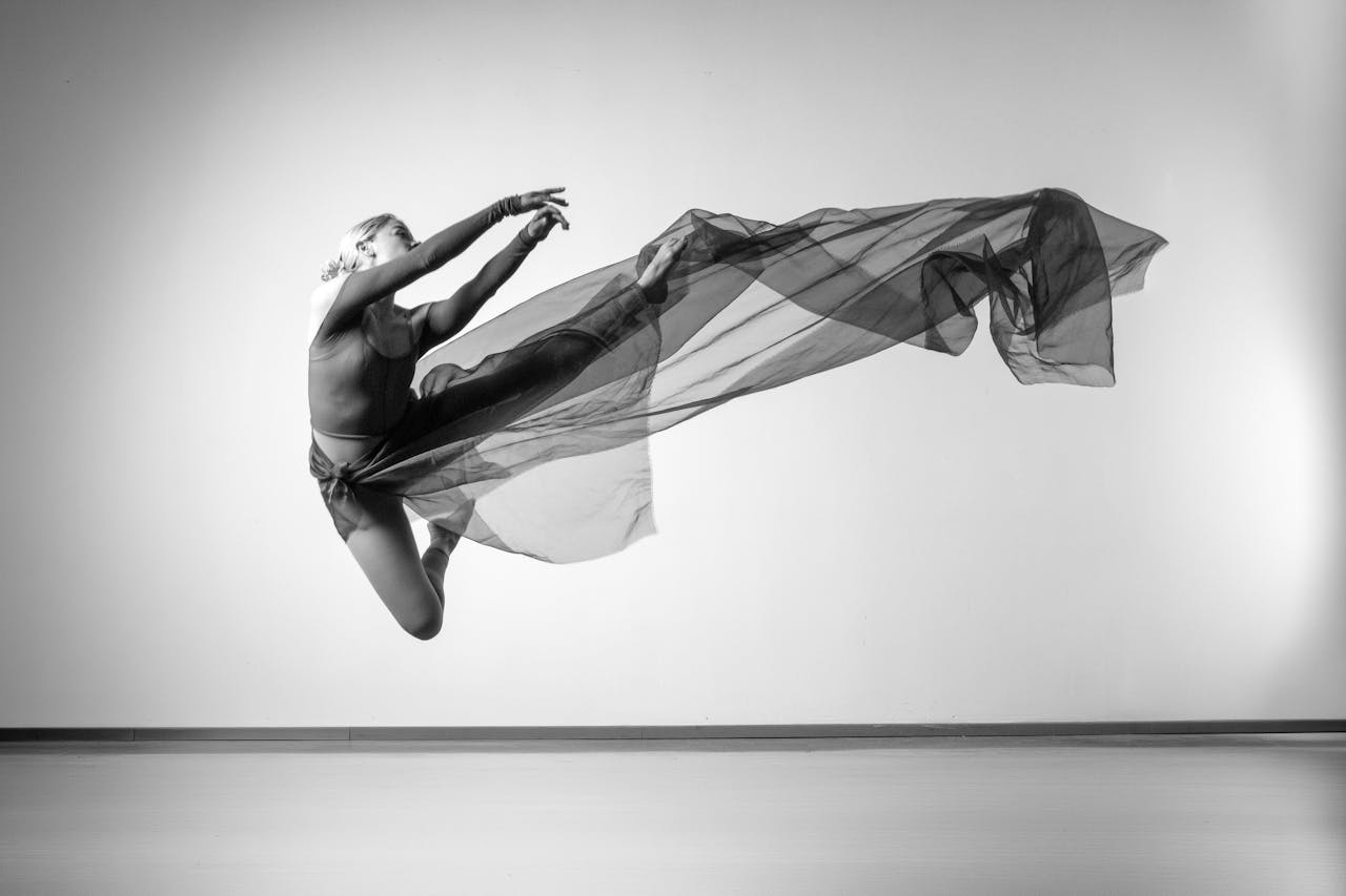 A captivating black and white photo of a female dancer in mid-air, showcasing grace and movement.